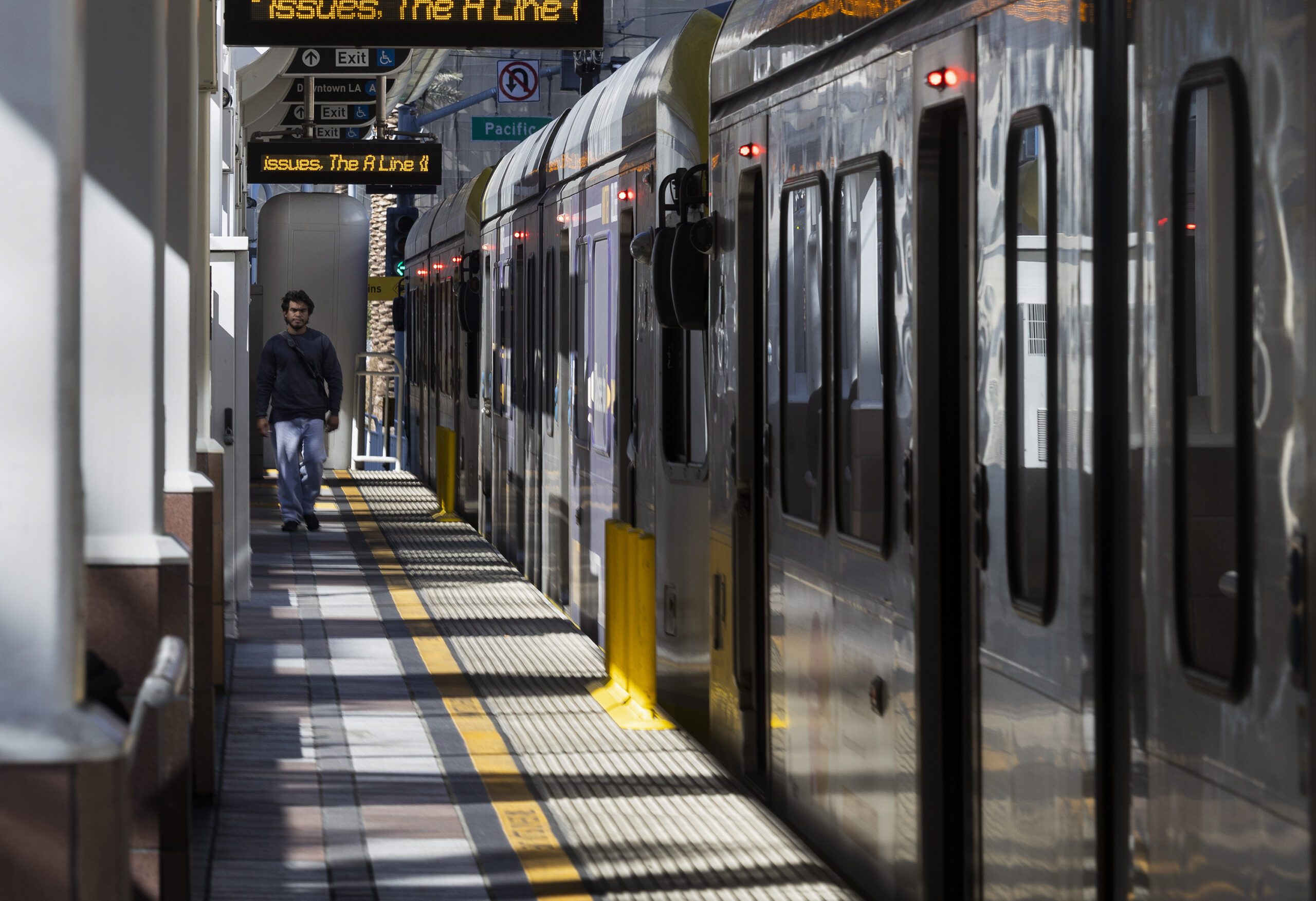 A man walks on a train platform.