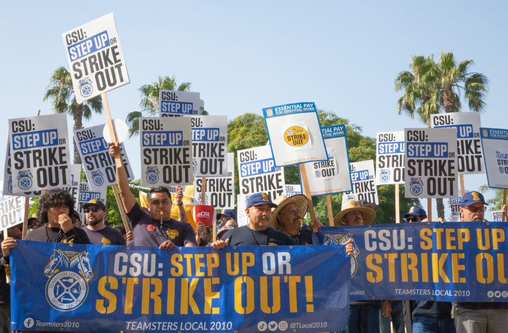 Union members protest with signs and banners. Signs reading "CSU: Step up or Strike Out!" are visible.