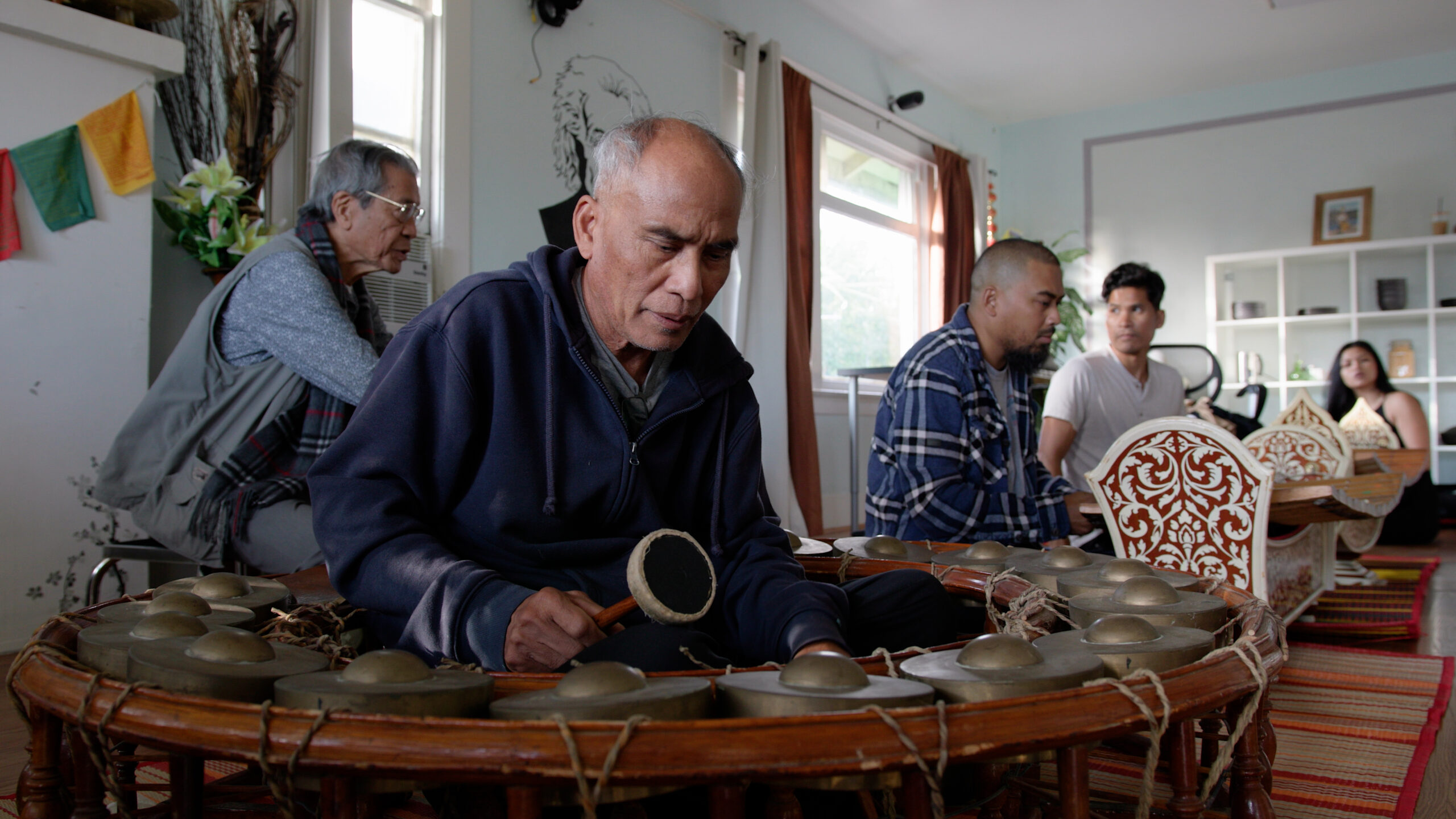 A man plays a traditional Cambodian instrument.
